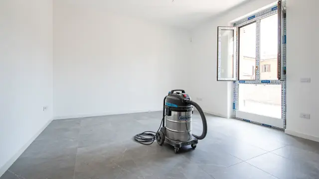 Appartamento appena ristrutturato con pavimento in gres grigio e aspiratore industriale